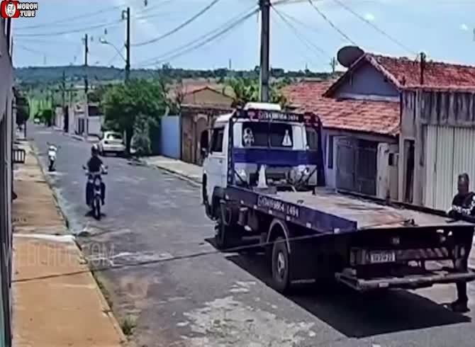 Video :By colliding with a cable that is positioned in the center of the road, this scooter rider barely avoids being beheaded